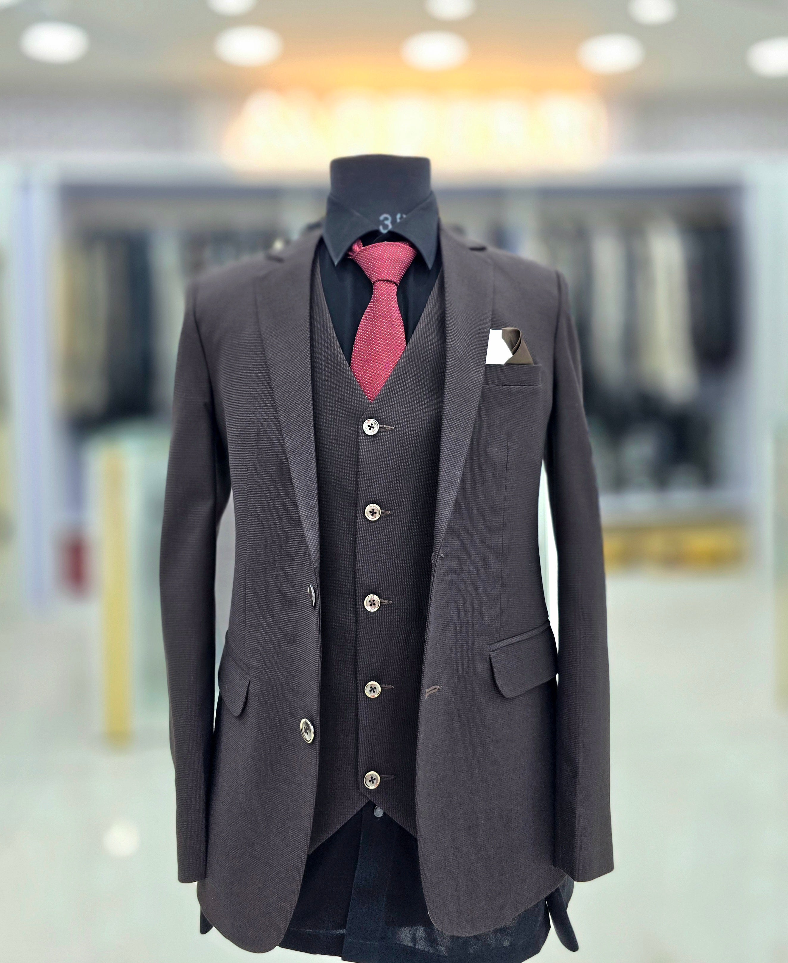 Solid brown coloured formal three piece suit with self design with pants blazer and waistcoat